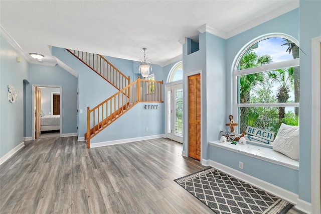 101 N 22nd St, Flagler Beach, FL 32136 - foyer entrance with stairway, wood finished floors, a chandelier, and ornamental molding