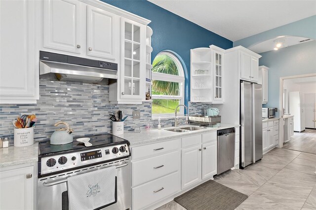 101 N 22nd St, Flagler Beach, FL 32136 - kitchen with stainless steel appliances, under cabinet range hood, white cabinetry, and arched walkways