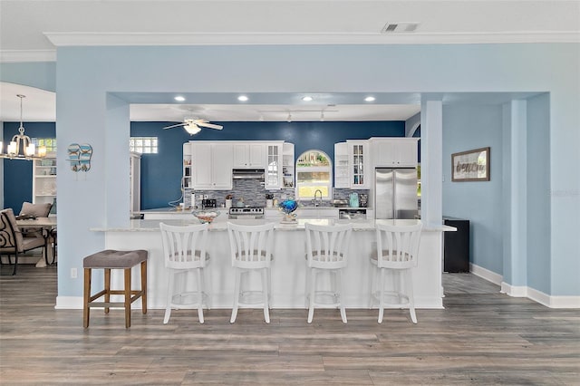 101 N 22nd St, Flagler Beach, FL 32136 - kitchen with appliances with stainless steel finishes, crown molding, wood finished floors, recessed lighting, and tasteful backsplash
