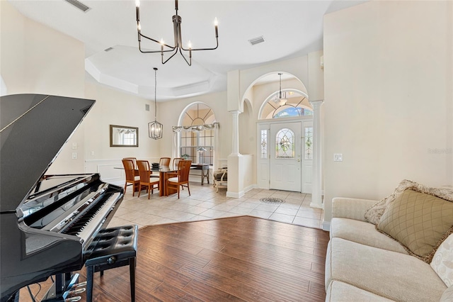68 Egret Trl, Palm Coast, FL 32164 - living room featuring ornate columns, a chandelier, arched walkways, and healthy amount of natural light