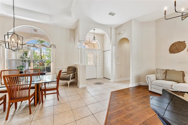 68 Egret Trl, Palm Coast, FL 32164 - foyer entrance with a chandelier, arched walkways, a raised ceiling, light tile patterned floors, and ornamental molding