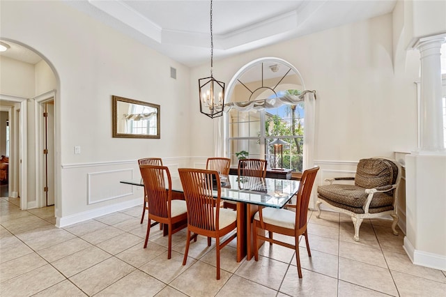68 Egret Trl, Palm Coast, FL 32164 - dining room featuring light tile patterned flooring, ornamental molding, wainscoting, arched walkways, and a raised ceiling