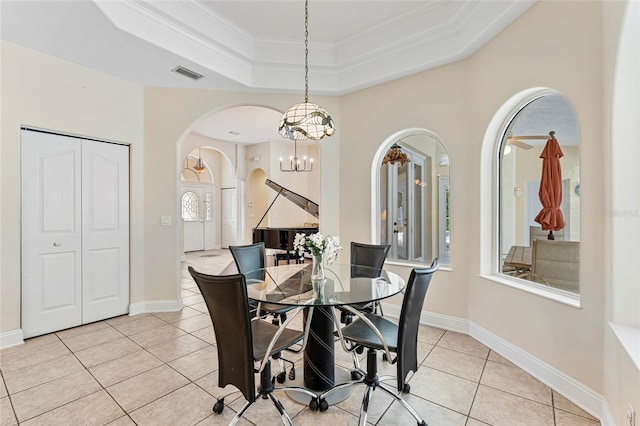 68 Egret Trl, Palm Coast, FL 32164 - dining space featuring arched walkways, light tile patterned flooring, a chandelier, crown molding, and a raised ceiling