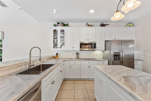 68 Egret Trl, Palm Coast, FL 32164 - kitchen with stainless steel appliances, glass insert cabinets, white cabinetry, light stone countertops, and a textured ceiling