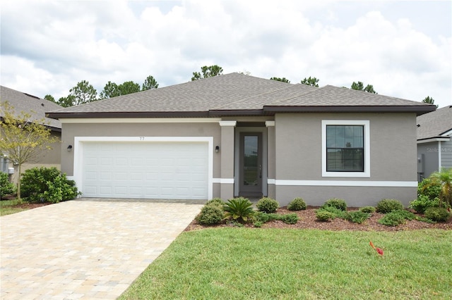 77 Green Cir, Palm Coast, FL 32164 - view of front of home with stucco siding, roof with shingles, decorative driveway, a front yard, and an attached garage