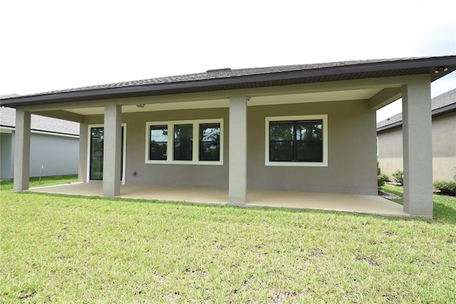 77 Green Cir, Palm Coast, FL 32164 - rear view of house featuring a patio, stucco siding, and a yard