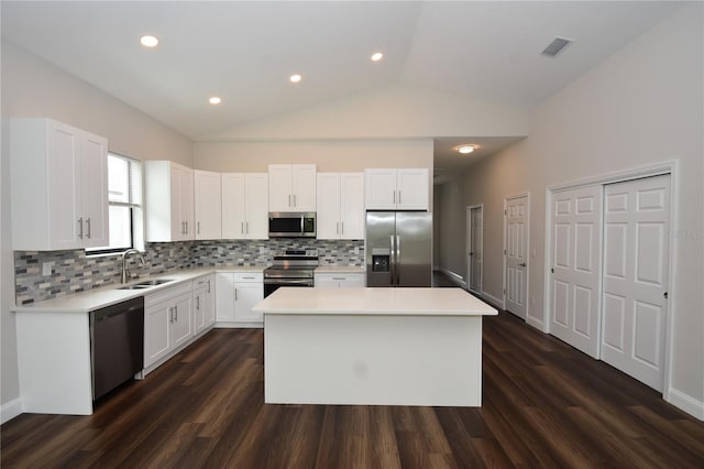 77 Green Cir, Palm Coast, FL 32164 - kitchen with appliances with stainless steel finishes, backsplash, vaulted ceiling, a kitchen island, and light countertops
