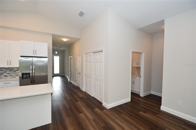 77 Green Cir, Palm Coast, FL 32164 - kitchen with stainless steel fridge, light countertops, white cabinetry, dark wood finished floors, and vaulted ceiling
