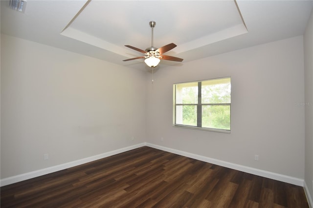 77 Green Cir, Palm Coast, FL 32164 - spare room featuring a raised ceiling, dark wood-type flooring, and a ceiling fan