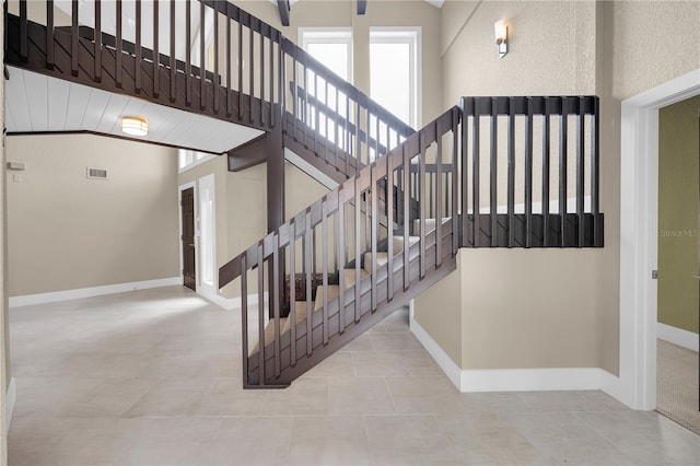 9353 Old A1A, Saint Augustine, FL 32080 - staircase featuring tile patterned flooring and high vaulted ceiling