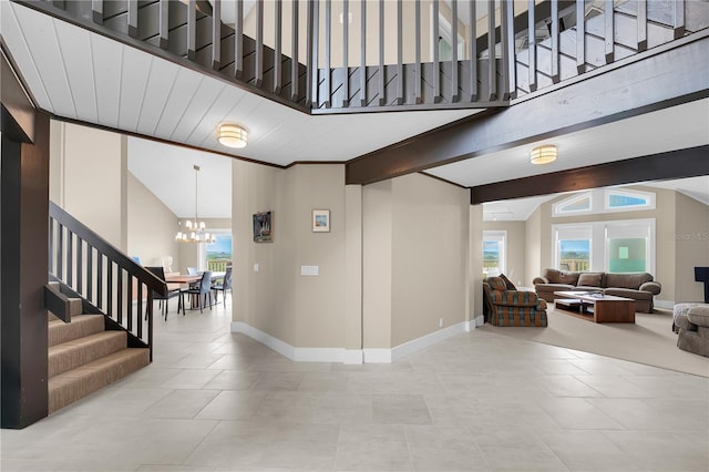 9353 Old A1A, Saint Augustine, FL 32080 - stairway with a chandelier, tile patterned flooring, beam ceiling, and high vaulted ceiling