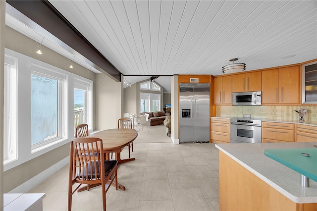 9353 Old A1A, Saint Augustine, FL 32080 - kitchen with stainless steel appliances, wooden ceiling, backsplash, glass insert cabinets, and light brown cabinetry