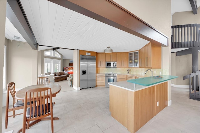 9353 Old A1A, Saint Augustine, FL 32080 - kitchen with stainless steel appliances, a peninsula, tasteful backsplash, light tile patterned floors, and glass insert cabinets