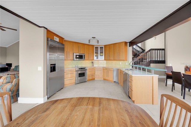 9353 Old A1A, Saint Augustine, FL 32080 - kitchen featuring stainless steel appliances, light brown cabinets, a peninsula, tasteful backsplash, and glass insert cabinets