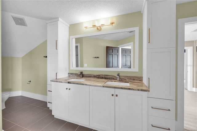 9353 Old A1A, Saint Augustine, FL 32080 - full bathroom with double vanity, a textured ceiling, and tile patterned floors