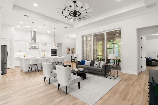 476 Stirling Bridge Dr, Ormond Beach, FL 32174 - living area with a tray ceiling, a chandelier, recessed lighting, and light wood finished floors