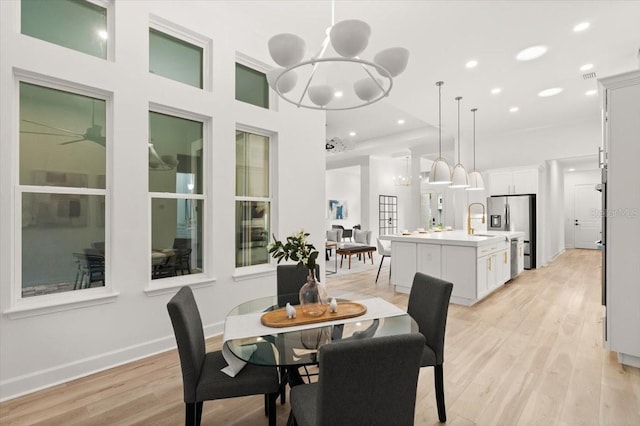 476 Stirling Bridge Dr, Ormond Beach, FL 32174 - dining room featuring a chandelier, light wood-style floors, recessed lighting, and a towering ceiling