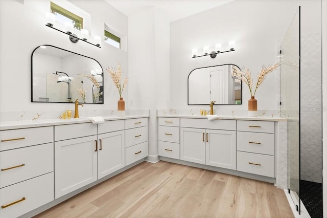 476 Stirling Bridge Dr, Ormond Beach, FL 32174 - bathroom featuring tiled shower, wood finished floors, and two vanities