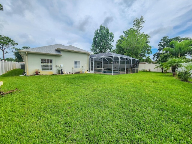 8 Wiltshire Pl, Palm Coast, FL 32164 - back of property featuring a fenced backyard, stucco siding, and a lanai