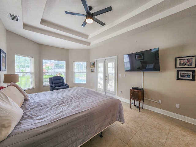 8 Wiltshire Pl, Palm Coast, FL 32164 - bedroom featuring multiple windows, a tray ceiling, access to outside, and light tile patterned floors