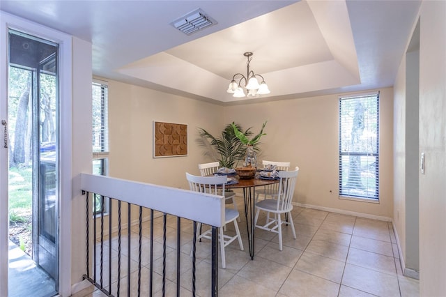 11 Surrey Ct Unit 11, Palm Coast, FL 32137 - dining area featuring a tray ceiling, healthy amount of natural light, a chandelier, and tile patterned flooring