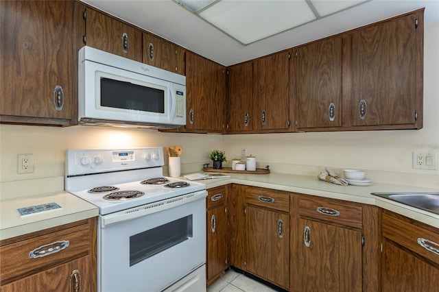 11 Surrey Ct Unit 11, Palm Coast, FL 32137 - kitchen with white appliances, light countertops, and light tile patterned flooring