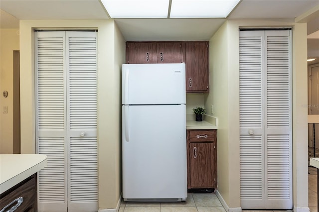 11 Surrey Ct Unit 11, Palm Coast, FL 32137 - kitchen featuring freestanding refrigerator, light countertops, dark brown cabinets, and light tile patterned flooring