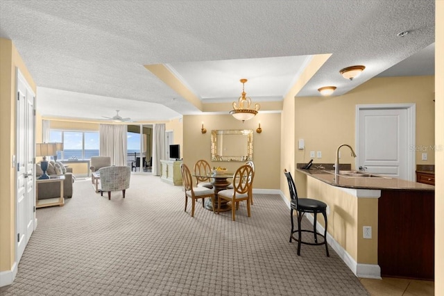 200 Ocean Crest Dr Unit 813, Palm Coast, FL 32137 - dining space with carpet, a textured ceiling, ornamental molding, ceiling fan, and a raised ceiling