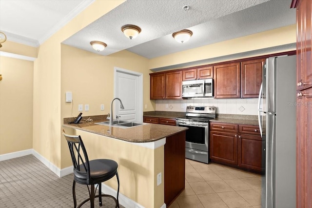 200 Ocean Crest Dr Unit 813, Palm Coast, FL 32137 - kitchen featuring appliances with stainless steel finishes, a kitchen breakfast bar, a peninsula, crown molding, and decorative backsplash