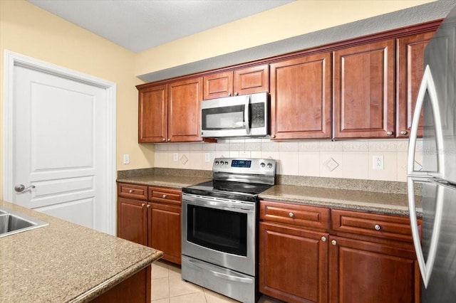 200 Ocean Crest Dr Unit 813, Palm Coast, FL 32137 - kitchen featuring stainless steel appliances, brown cabinetry, light tile patterned floors, and tasteful backsplash