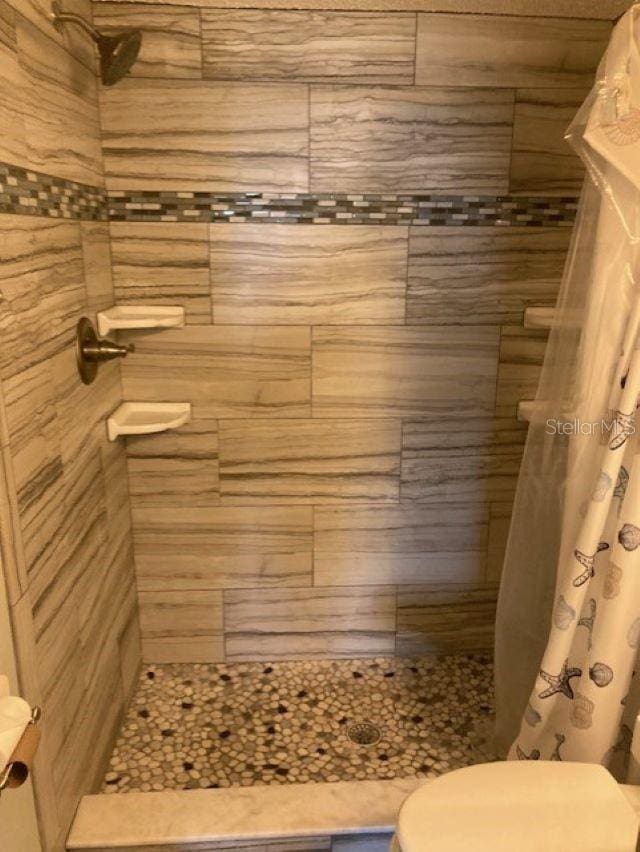 6300 A1A S Unit A11U, Saint Augustine, FL 32080 - bathroom featuring tiled shower and toilet