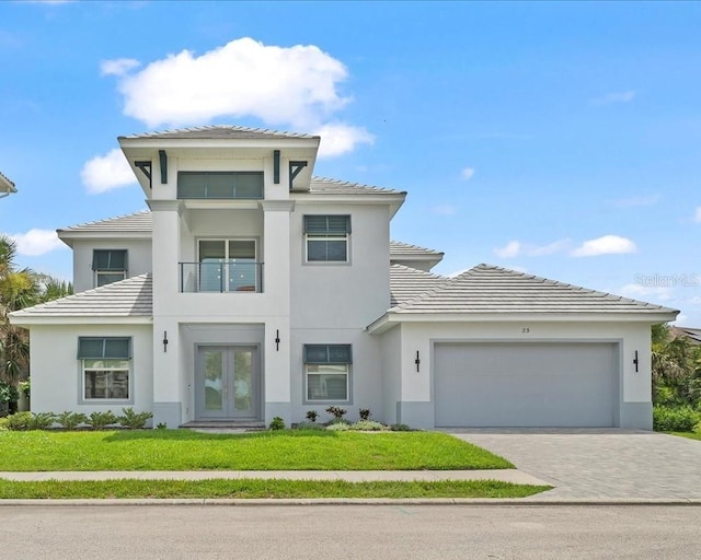 23 Ocean Ridge Blvd N, Palm Coast, FL 32137 - view of front of house with french doors, a garage, a front yard, and driveway