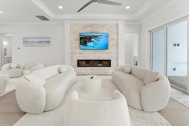 23 Ocean Ridge Blvd N, Palm Coast, FL 32137 - living room featuring crown molding, wood finished floors, a raised ceiling, a ceiling fan, and a large fireplace