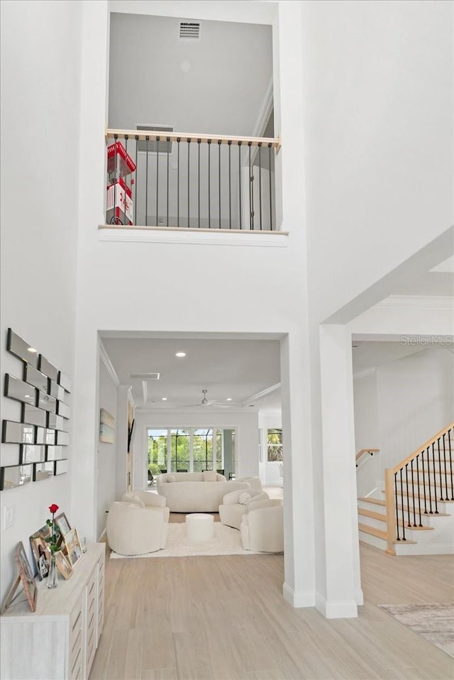 23 Ocean Ridge Blvd N, Palm Coast, FL 32137 - stairway with wood finished floors, a high ceiling, and crown molding