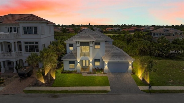 23 Ocean Ridge Blvd N, Palm Coast, FL 32137 - view of front of property featuring a tiled roof, driveway, stucco siding, a garage, and a front lawn
