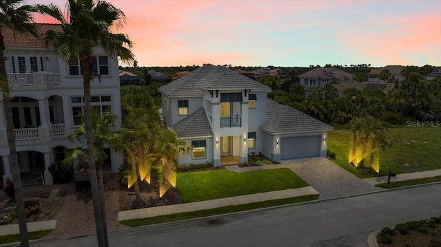 23 Ocean Ridge Blvd N, Palm Coast, FL 32137 - view of front of house featuring decorative driveway, an attached garage, stucco siding, a tile roof, and a front lawn