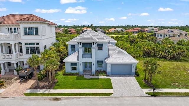 23 Ocean Ridge Blvd N, Palm Coast, FL 32137 - view of front of home with decorative driveway, a tile roof, stucco siding, a front lawn, and a residential view