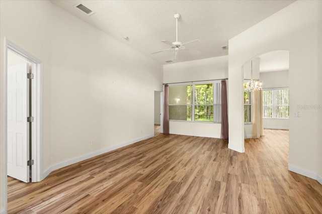 1707 Southern Belle Ln, Port Orange, FL 32128 - empty room with light wood-type flooring, ceiling fan, arched walkways, and a chandelier