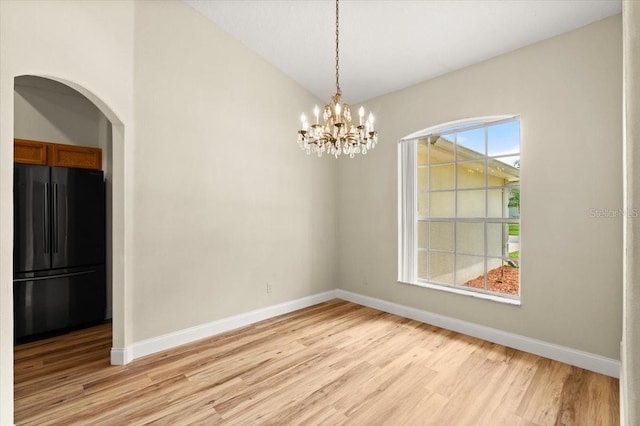 1707 Southern Belle Ln, Port Orange, FL 32128 - unfurnished dining area featuring light wood-type flooring, arched walkways, and a chandelier