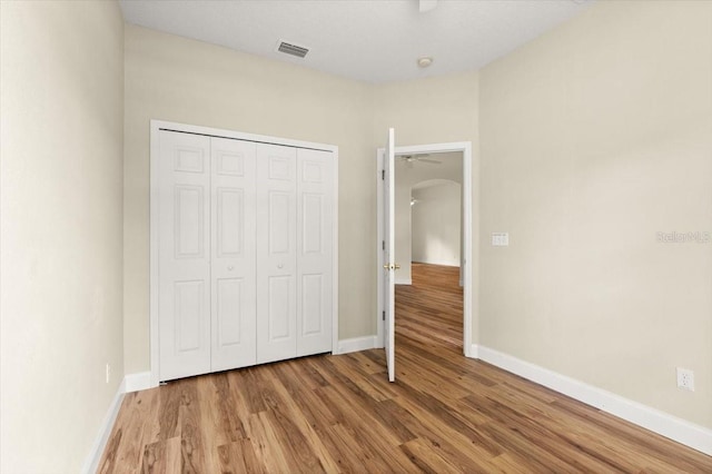 1707 Southern Belle Ln, Port Orange, FL 32128 - unfurnished bedroom featuring light wood-style flooring, arched walkways, and a closet