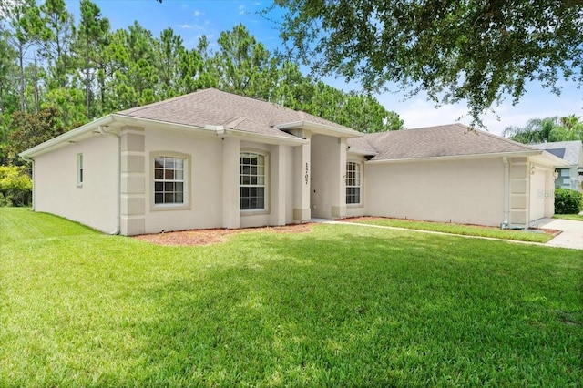 1707 Southern Belle Ln, Port Orange, FL 32128 - back of property with stucco siding, a lawn, a garage, roof with shingles, and driveway