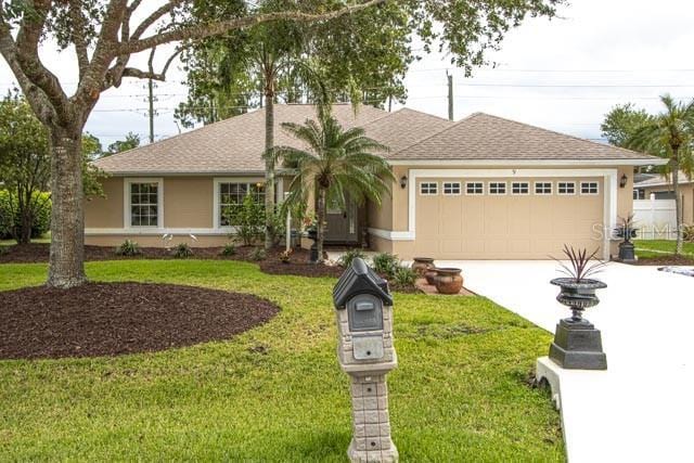 9 Empress Ln, Palm Coast, FL 32164 - single story home featuring an attached garage, concrete driveway, a front yard, roof with shingles, and stucco siding