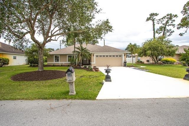 9 Empress Ln, Palm Coast, FL 32164 - ranch-style house with an attached garage, concrete driveway, and a front yard