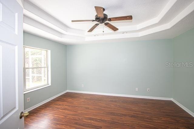 9 Empress Ln, Palm Coast, FL 32164 - unfurnished room featuring a raised ceiling, dark wood-style floors, and ceiling fan