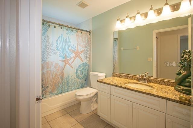 9 Empress Ln, Palm Coast, FL 32164 - bathroom with vanity, tile patterned floors, and shower / tub combo with curtain