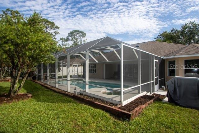 9 Empress Ln, Palm Coast, FL 32164 - back of property featuring an outdoor pool, a lawn, a patio, and glass enclosure