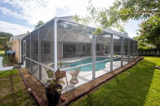 9 Empress Ln, Palm Coast, FL 32164 - back of house featuring an outdoor pool, a patio, a lanai, and a yard