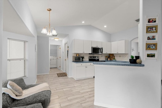 25 Round Mill Ln, Palm Coast, FL 32164 - kitchen with appliances with stainless steel finishes, washer / clothes dryer, white cabinetry, a chandelier, and dark countertops