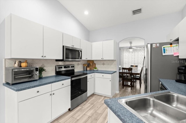 25 Round Mill Ln, Palm Coast, FL 32164 - kitchen featuring appliances with stainless steel finishes, ceiling fan, tasteful backsplash, white cabinets, and light wood-style floors