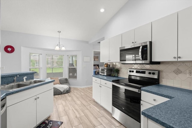 25 Round Mill Ln, Palm Coast, FL 32164 - kitchen with appliances with stainless steel finishes, dark countertops, lofted ceiling, tasteful backsplash, and recessed lighting